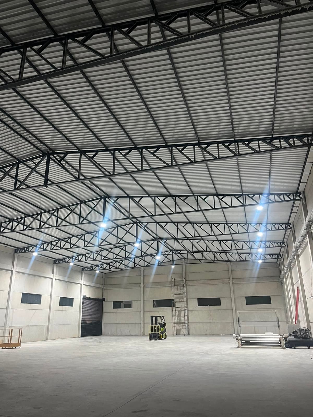 Galpão industrial com estrutura metálica e luminárias de LED de alta potência instaladas na cobertura
