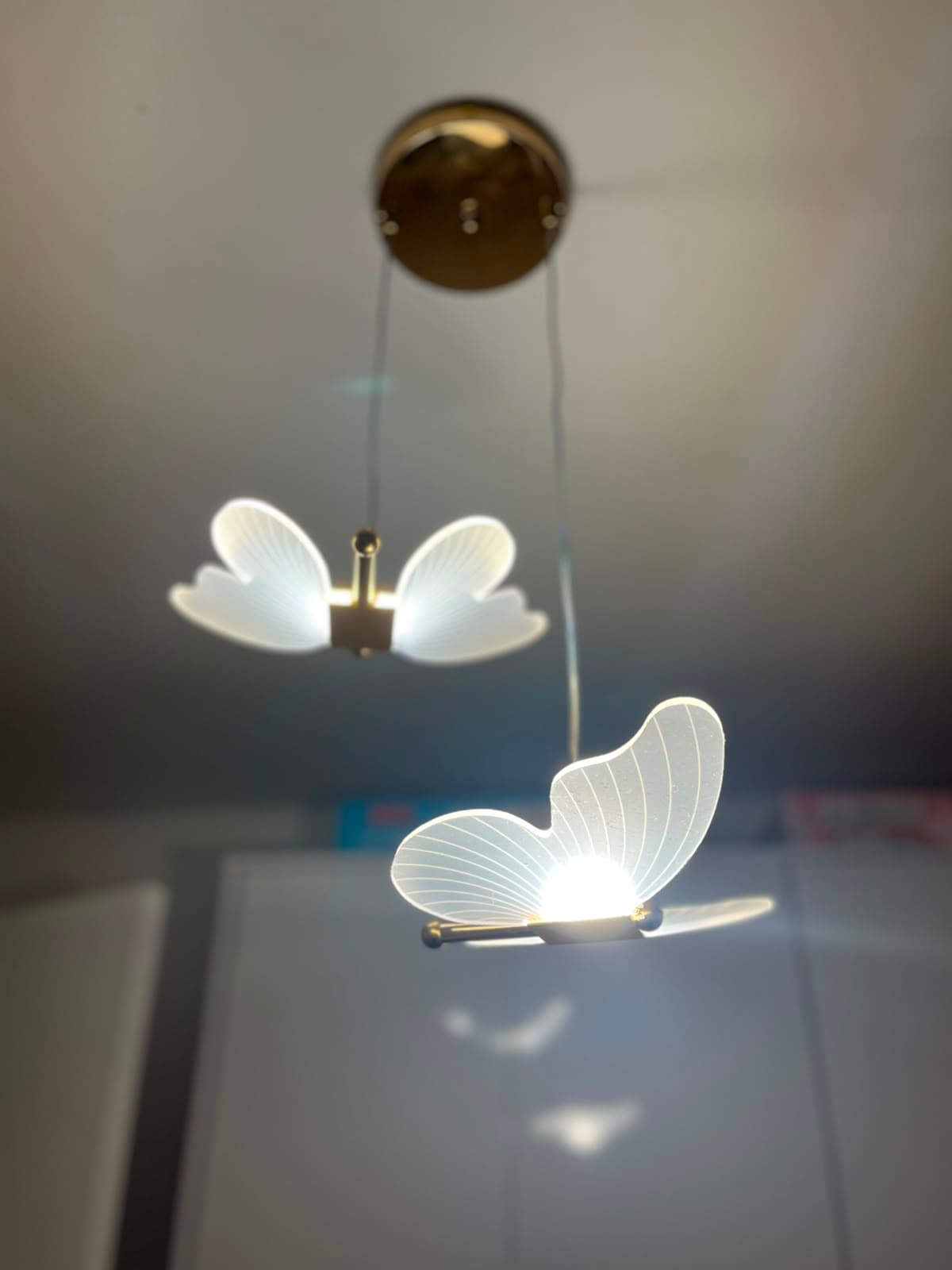 Pendentes decorativos em formato de borboleta instalados sobre bancada